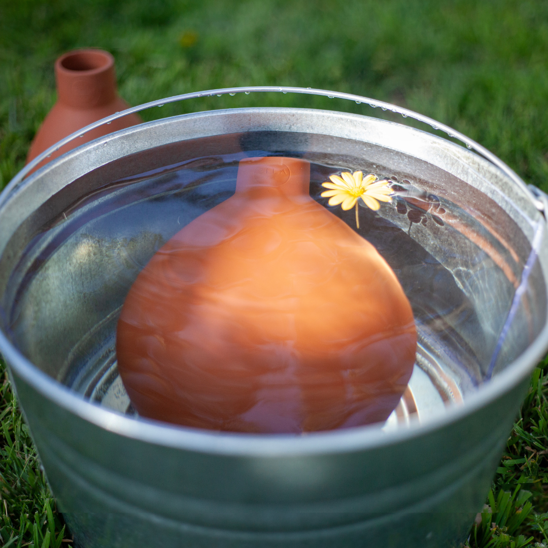 large olla pot soaking in a bucket with water for 15 min